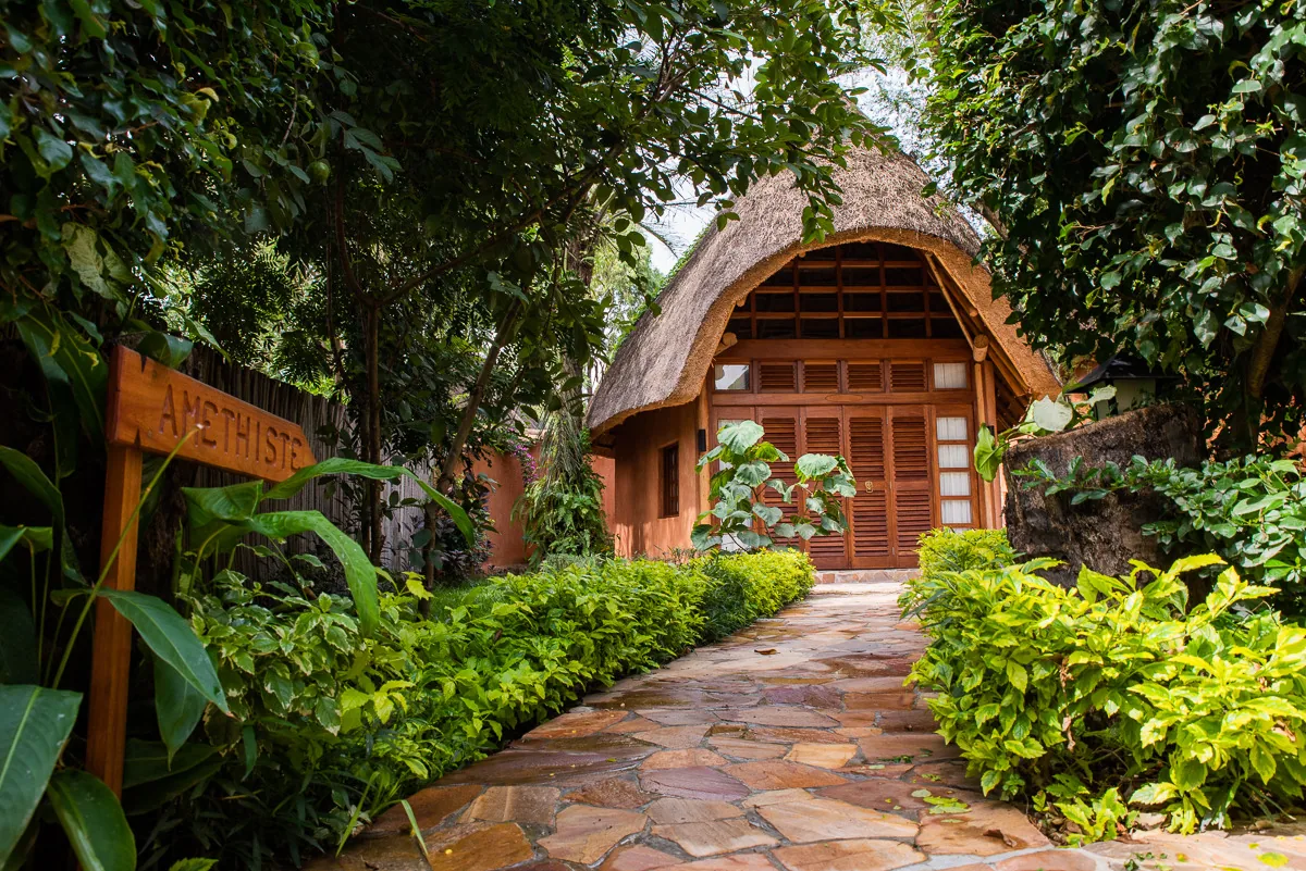 A flagstone path lined with shrubs leading to the Amethyst bungalow’s louvred wooden doors