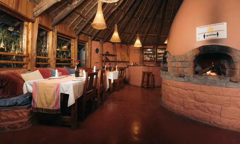 The round dining room in the evening, the wood-fired oven glowing