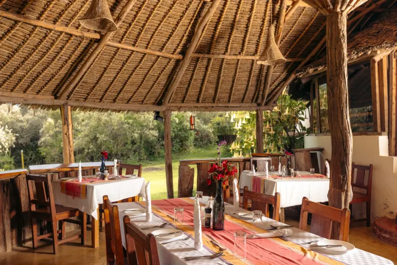 The thatched restaurant with tables laid in red and white, open to the garden